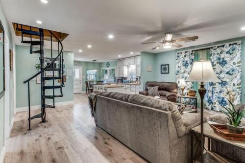 a living room with a couch and a spiral staircase at Stockyards! Less than 3 mins-Sleeps 8 -Gable House in Fort Worth