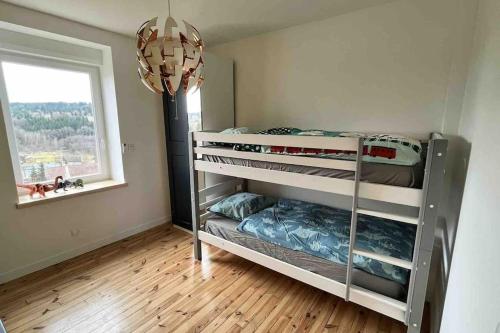 een slaapkamer met stapelbedden in een kamer met een raam bij Séjour coloré et relaxant in Le Chambon-sur-Lignon