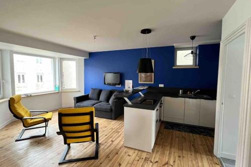 een woonkamer met een bank, een tafel en stoelen bij Séjour coloré et relaxant in Le Chambon-sur-Lignon