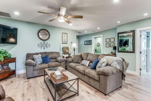 a living room with two couches and a ceiling fan at Stockyards! Less than 3 mins-Sleeps 8 -Gable House in Fort Worth