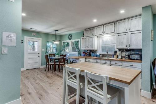a kitchen with white cabinets and a table and chairs at Stockyards! Less than 3 mins-Sleeps 8 -Gable House in Fort Worth