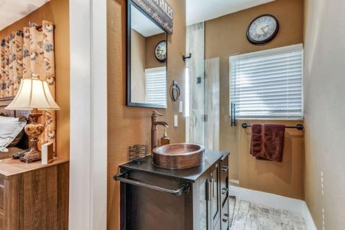 a bathroom with a sink and a shower with clocks on the wall at Stockyards! Less than 3 mins-Sleeps 8 -Gable House in Fort Worth