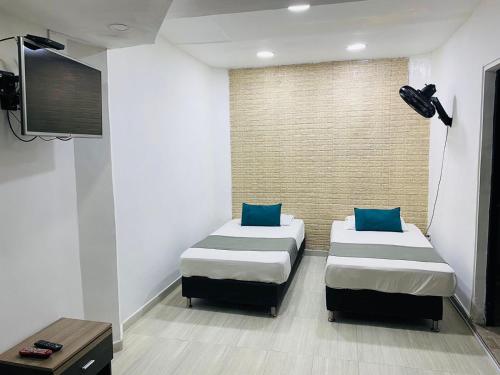 pokój z dwoma łóżkami i telewizorem w obiekcie HOTEL TREE HOUSE MEDELLiN w mieście Medellín