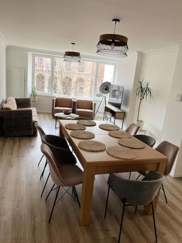 un salon avec une table et des chaises en bois dans l'établissement Le Milaz - Appartement classé 3* proche du lac - 8 personnes, à Thonon-les-Bains