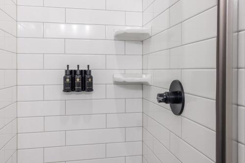 a white tiled bathroom with a shower with bottles at The Chill Zone in Ivins