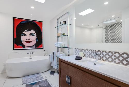 uma casa de banho com uma grande pintura de uma mulher na parede em Eclectic & Comfortable Canyon Corridor - A Ryson Property em Palm Springs