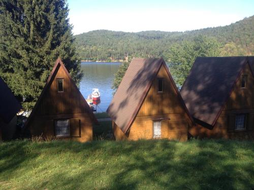 a couple of houses with a boat in the water at Autocamp Skalice in Slapy