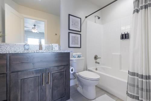 a bathroom with a toilet and a sink and a tub at Triple R Getaway in Ivins