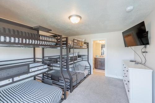 a room with three bunk beds and a television at Triple R Getaway in Ivins