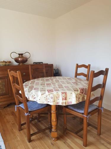 a dining room table with two chairs and a table with a tablecloth at Escapade entre mer et terre in Berneval-le-Grand