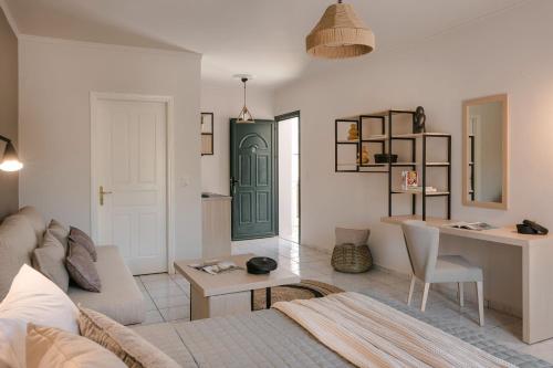 a living room with a bed and a table and a green door at Rosilion Studios & Apartments in Katelios