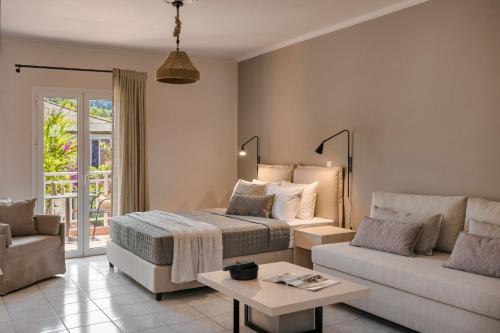 a bedroom with a bed and a couch and a table at Rosilion Studios & Apartments in Katelios