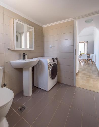 a bathroom with a washing machine and a sink at Brizet Apartments Sea & Side Sea View in Pollonia