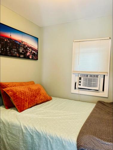 a bedroom with a bed and a window with a fan at Fancy studio private entrance in Selden