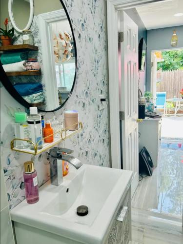 W łazience znajduje się umywalka i lustro. w obiekcie Fancy studio private entrance w mieście Selden