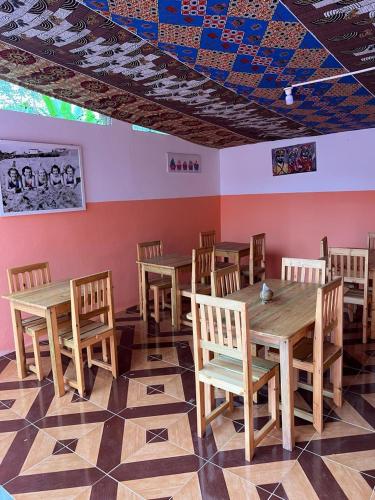 comedor con mesas de madera y sillas de madera en Residencial Pensão Bom Desconto, en Principe