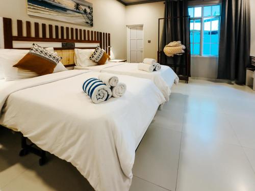 2 Betten in einem Schlafzimmer mit weißer Bettwäsche und Handtüchern in der Unterkunft Holiday home in Kamadhoo Island / Maldives in Kamadhoo