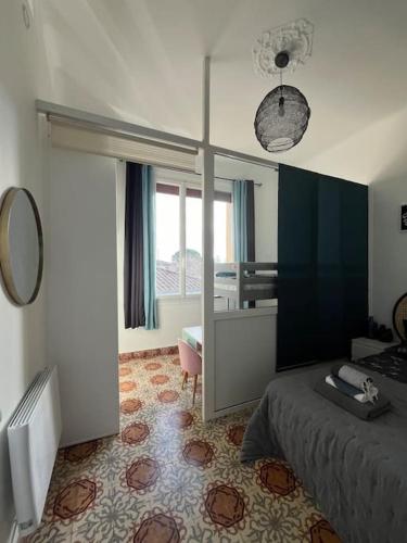 une chambre avec un lit et une grande fenêtre dans l'établissement Le l'islois- Park&Piscine, à LʼIsle-sur-la-Sorgue