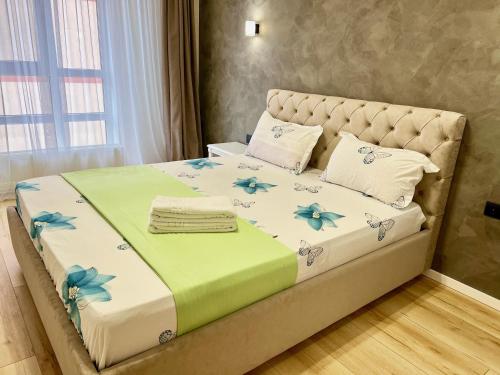 ein Schlafzimmer mit einem großen Bett mit blauen Blumen darauf in der Unterkunft Apartament AirPort Chisinau in Chişinău
