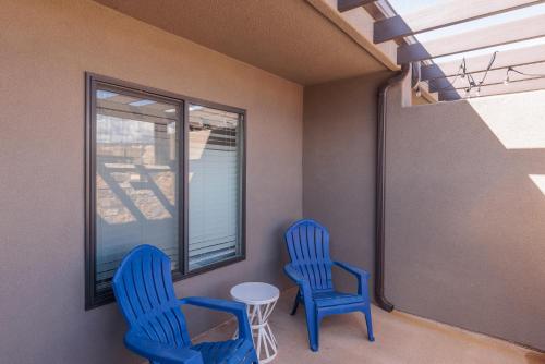two blue chairs and a table in a room with a window at Peaceful Easy Feeling in Ivins