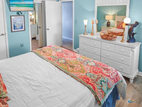 ein Schlafzimmer mit einem großen Bett und einer Kommode in der Unterkunft Island Surf #5 in Fort Walton Beach