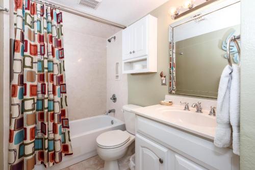 La salle de bains est pourvue d'un lavabo, de toilettes et d'un rideau de douche. dans l'établissement Island Surf #5, à Fort Walton Beach