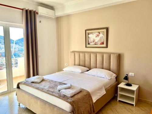 a bedroom with a bed and a window at Apartments Klajdi in Sarandë