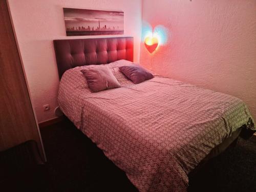 a bedroom with a bed with a pink headboard and a lamp at Appartement au coeur du Paris. in Paris