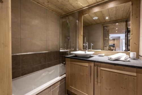 a bathroom with a sink and a bath tub at Résidence LA GRANGE AUX FEES - Appartement GRANGE AUX FEES E04 pour 8 Personnes in Valmorel