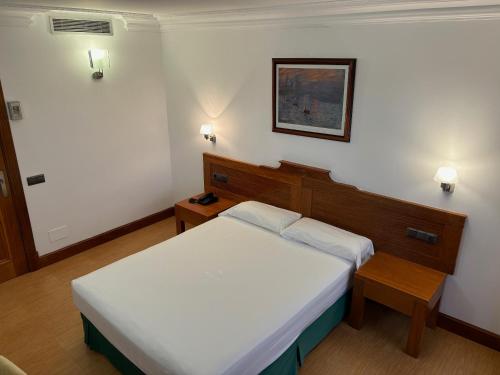a small bedroom with a bed and a table at Gran Hotel Liber & Spa Playa Golf in Noja