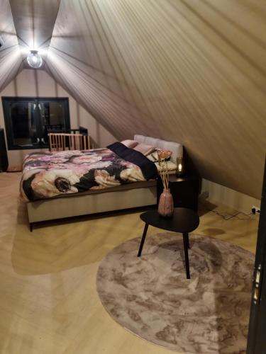 ein Schlafzimmer mit einem Bett, einem Tisch und einem Stuhl in der Unterkunft B&B in de Roos in Noordbergum