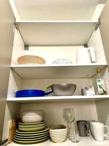 a cabinet filled with plates and bowls and dishes at Lugano Gem Mini Suite Moderna in Lugano