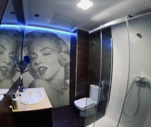 a bathroom with a picture of a woman on the wall at Ático os porches in Allariz