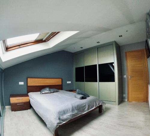 a bedroom with a bed and a skylight at Ático os porches in Allariz