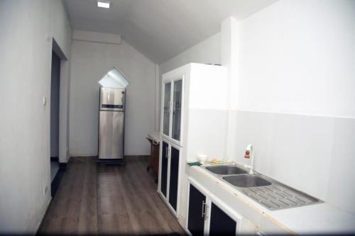 een keuken met een wastafel en een koelkast bij Ovenmin Villa in Haburugala
