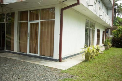 een gebouw met glazen schuifdeuren aan de zijkant bij Ovenmin Villa in Haburugala