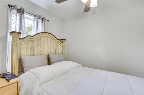 een slaapkamer met een wit bed en een houten hoofdeinde bij Charming Sylvester Apartment - 17 Mi to Albany! in Sylvester