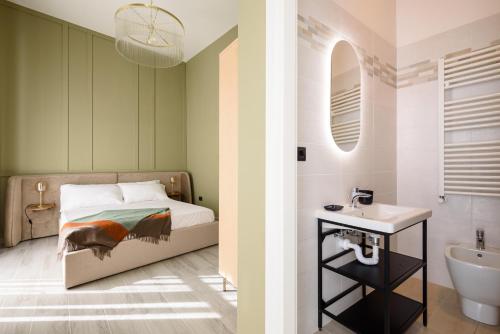 a bedroom with a bed and a sink and a mirror at Pavean Suites Frattamaggiore in Frattamaggiore