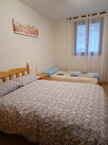 1 Schlafzimmer mit 2 Betten und einem Fenster in der Unterkunft Apartamento Viman in Canfranc-Estación