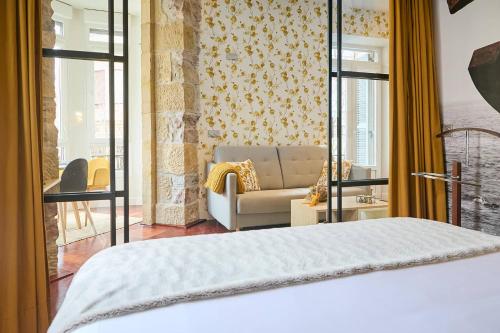 um quarto com uma cama, um sofá e janelas em HAMAR San Sebastián em San Sebastián