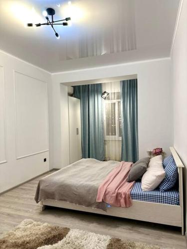 una camera da letto con un grande letto con tende blu di Жилой комплекс Махаббат ad Aqtau