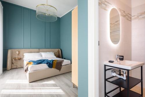 een slaapkamer met blauwe muren en een bed met een wastafel bij Pavean Suites Frattamaggiore in Frattamaggiore