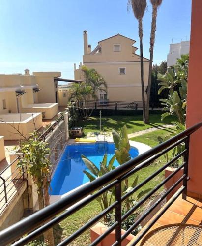 un balcon avec une piscine et une maison dans l'établissement Studio Añoreta Playa y Golf, à Torre de Benagalbón