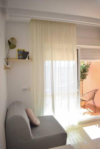 - un salon avec un canapé et une fenêtre dans l'établissement Studio Añoreta Playa y Golf, à Torre de Benagalbón