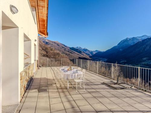 a table on a balcony with mountains in the background at Holiday Home Vitali by Interhome in Taceno