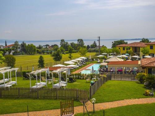 a view of a resort with a pool and chairs at Apartment Karina-2 by Interhome in Moniga