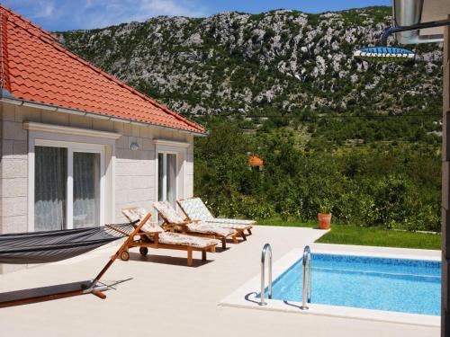 una hamaca y sillas junto a una piscina en Holiday Home Villa Župa by Interhome, en Roglići
