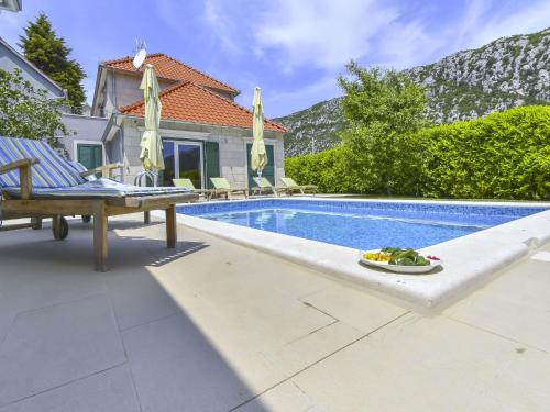 Villa con piscina con banco y plato de comida en Holiday Home Villa Župa by Interhome, en Roglići