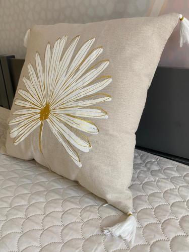 a pillow with a flower on it on a bed at Pokoje u Daniela in Miedzygorze