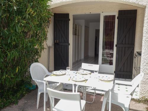 a white table and chairs on a patio at Apartment Jardins de la mer-10 by Interhome in Saint-Cyr-sur-Mer